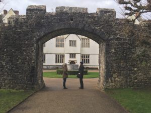 Two people standing under a stone archway.