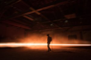 A photo showing a person inside a warehouse or empty, while wearing a VR headset. 